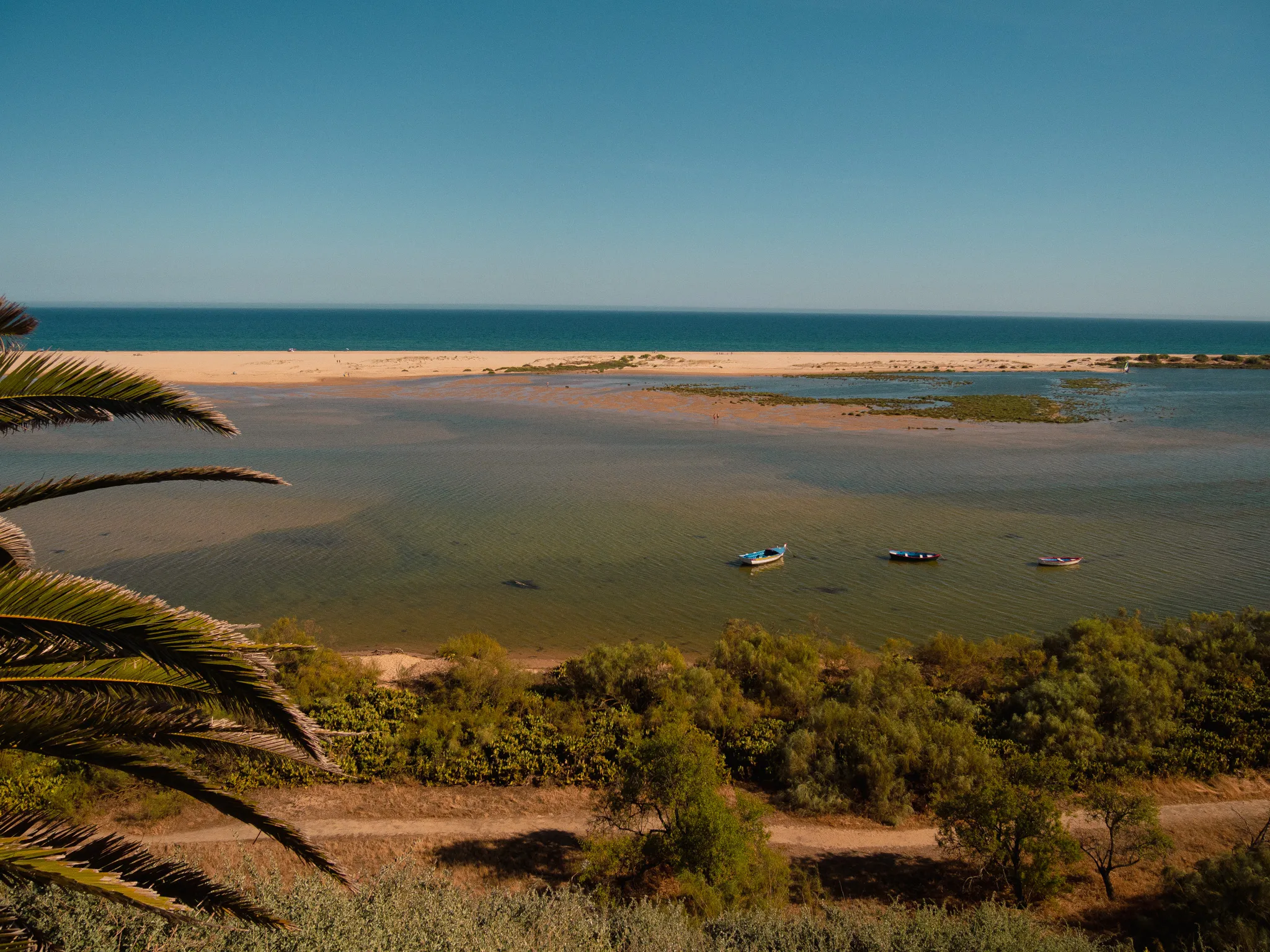 People wading across the sandbanks below Cacela Velha