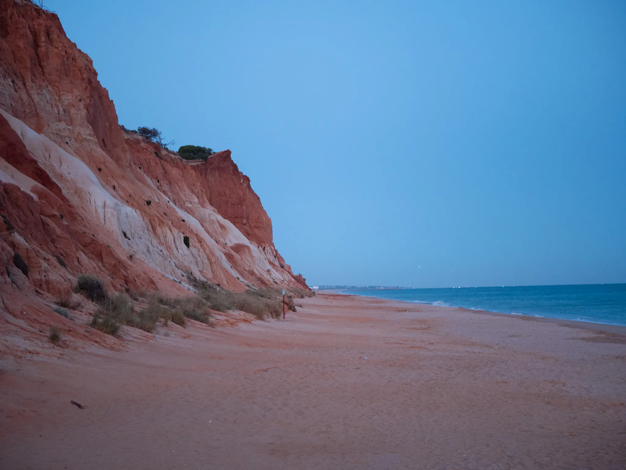 The striped ochre cliffs and turquoise shallows of Praia da Falésia
