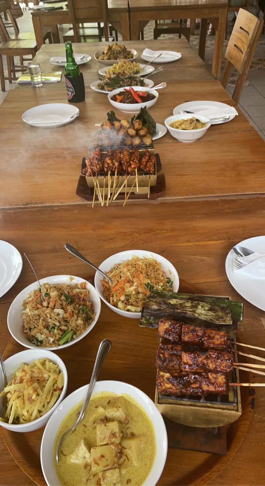 Cooking class results on a long table: satay, curry and salads