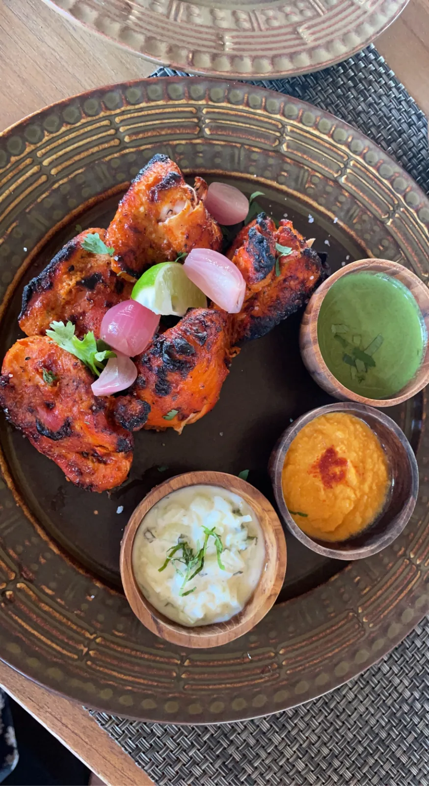 Grilled chicken with three dips on a brass plate