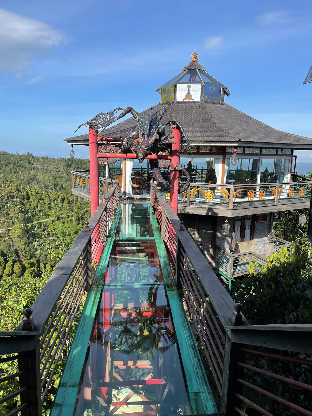 The glass walkway and tower restaurant in daylight, blue sky