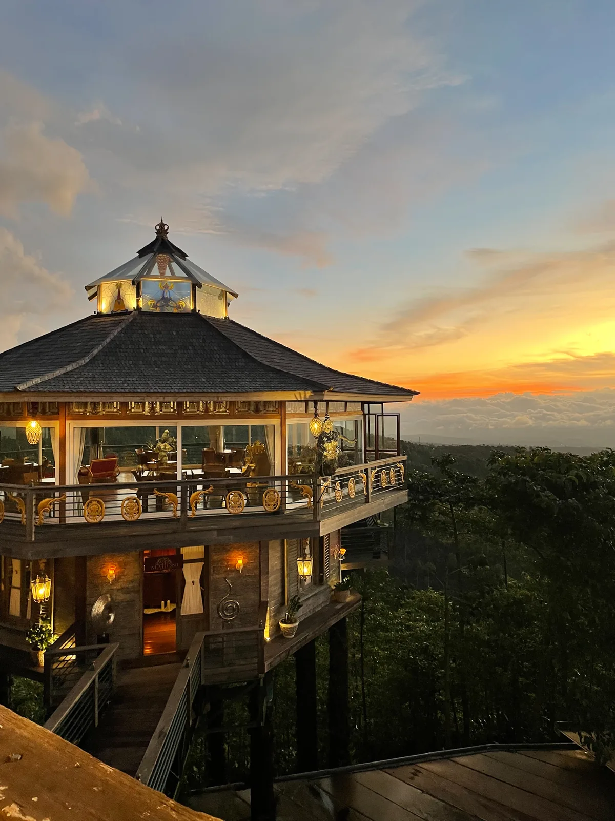The tower restaurant glowing at sunset above the forest
