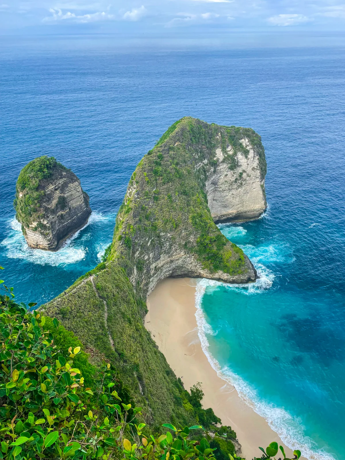 The Kelingking T-Rex cliff and beach on Nusa Penida from the top viewpoint, turquoise water below