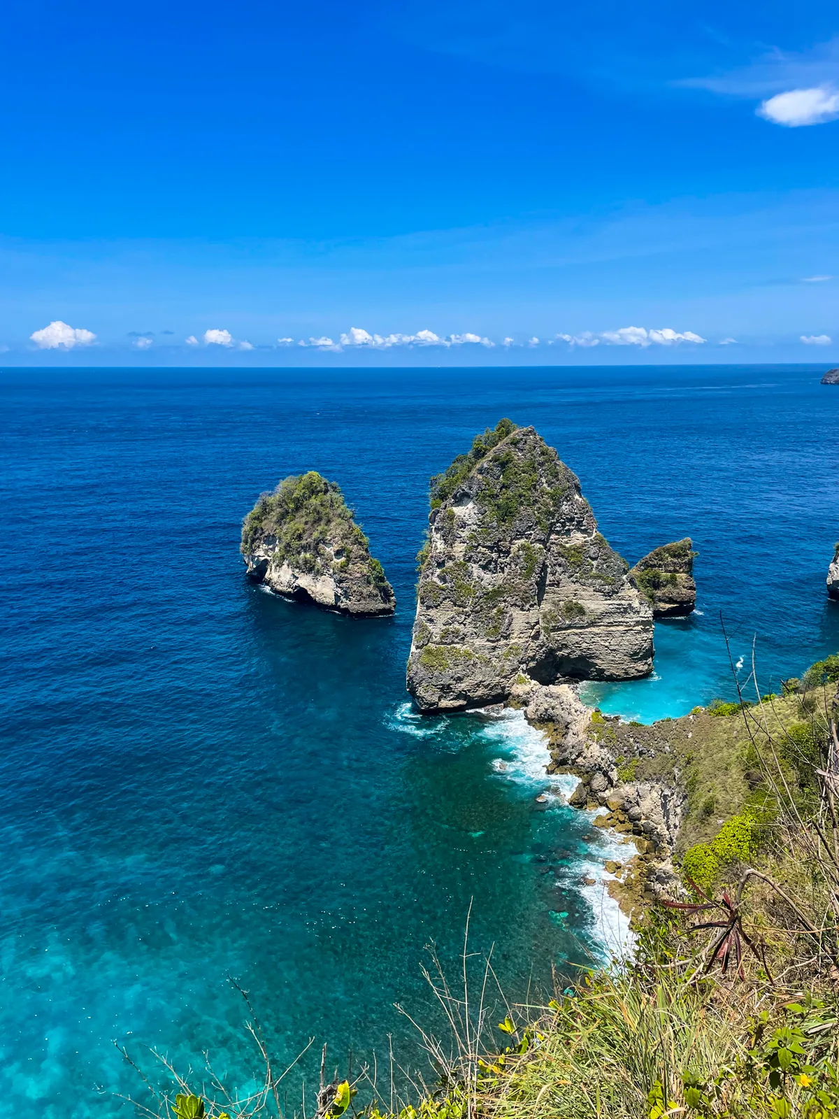 Rock stacks rising out of deep blue water off Nusa Penida