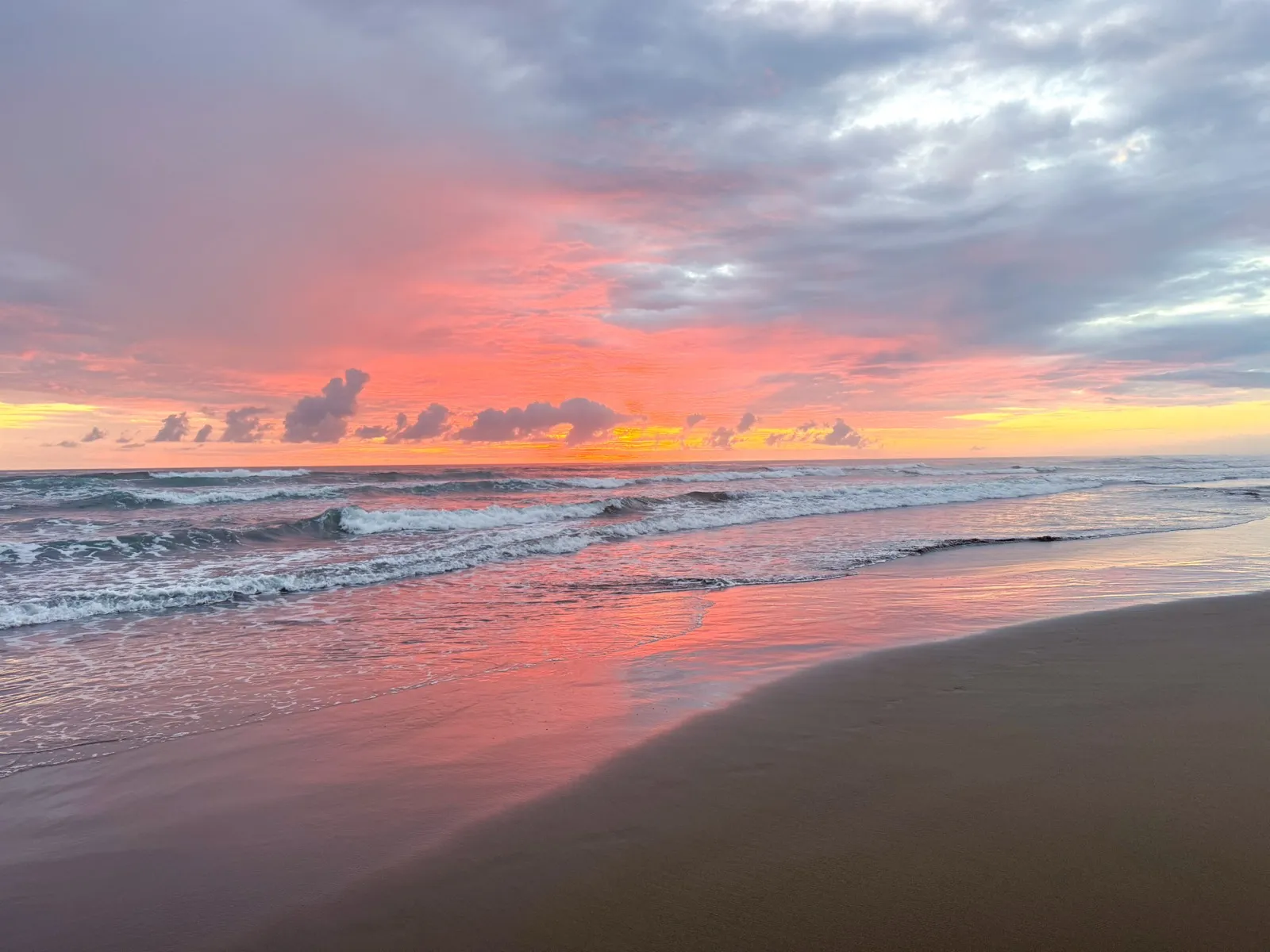 Sunset over Playa Linda, the sky turning soft shades of pink and reflecting across the ocean
