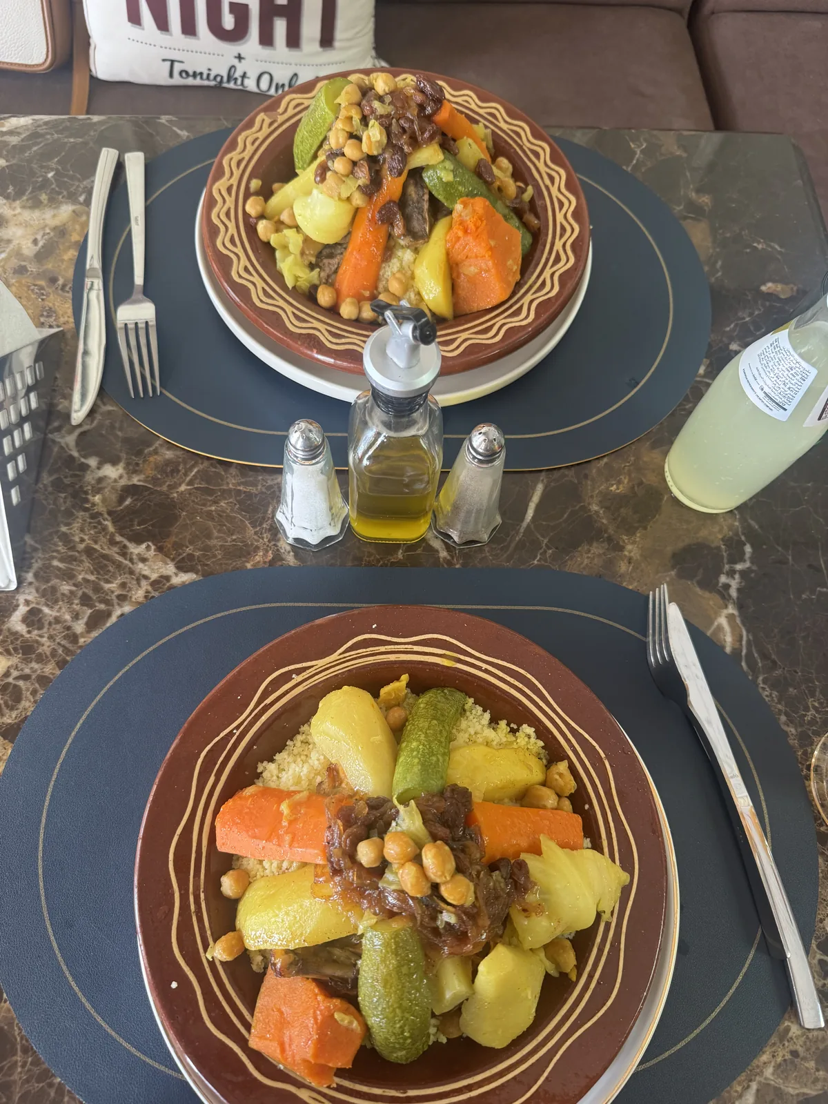 Two plates of Moroccan couscous with vegetables and caramelised onions