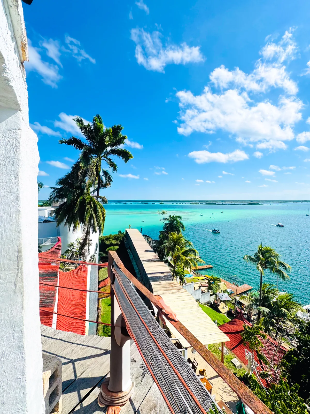 A high terrace with a white tower looking out over the lagoon and moored boats
