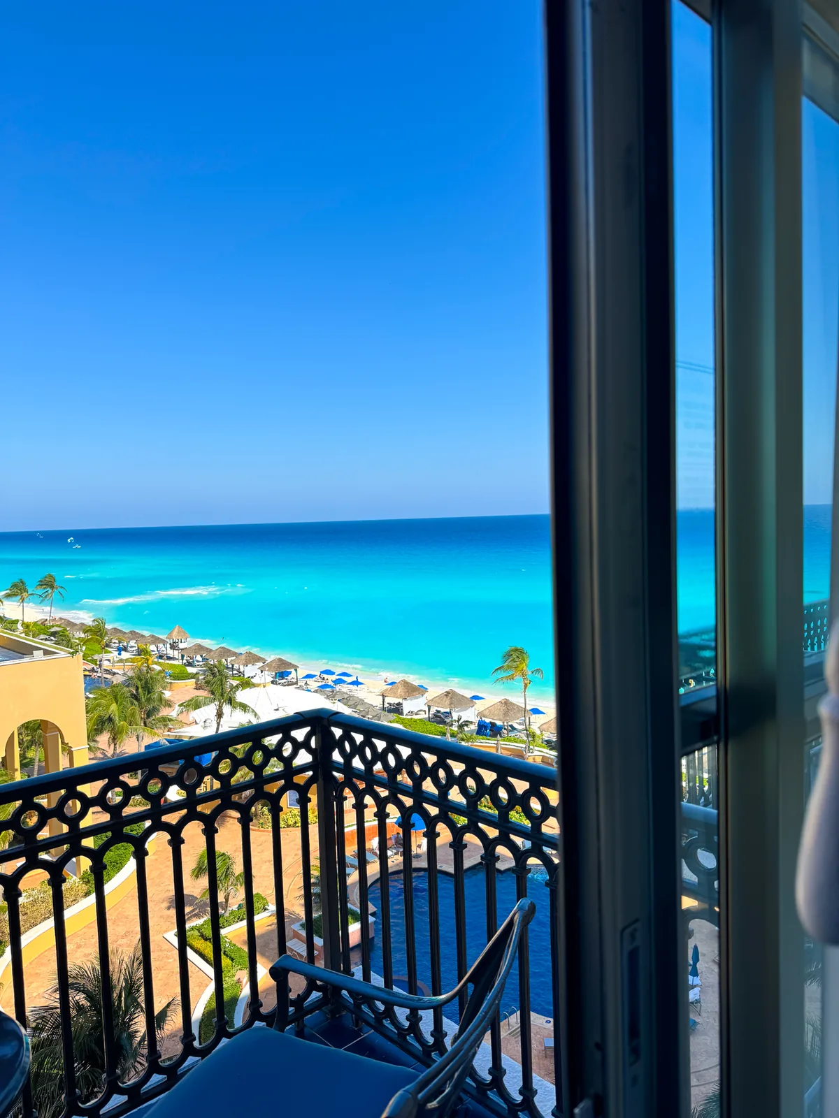 The balcony view over the beach and the turquoise sea at the Kempinski, window frame at the edge