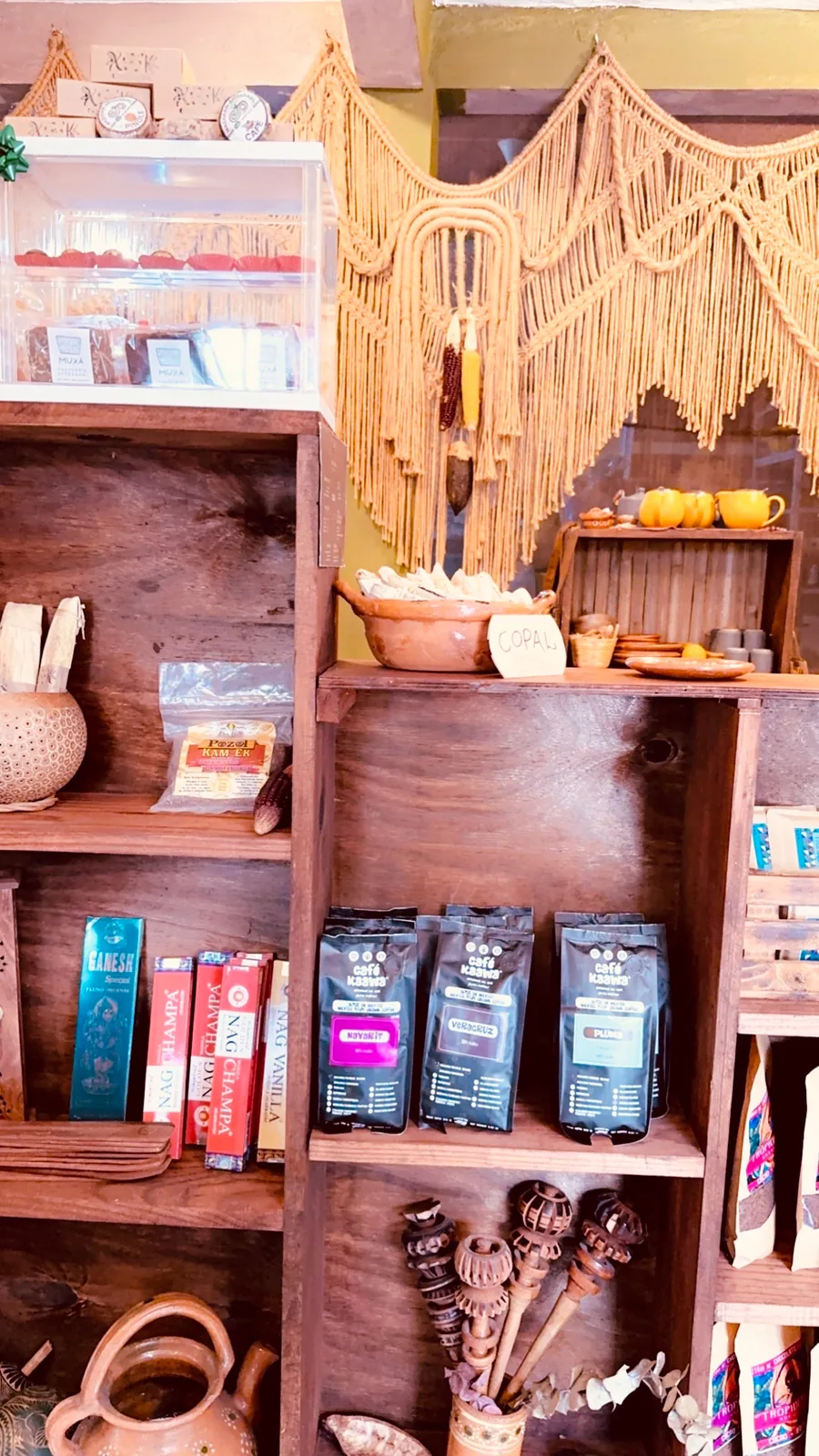 Wooden shelves of coffee bags, copal, incense and macramé in a shop in Tulum town